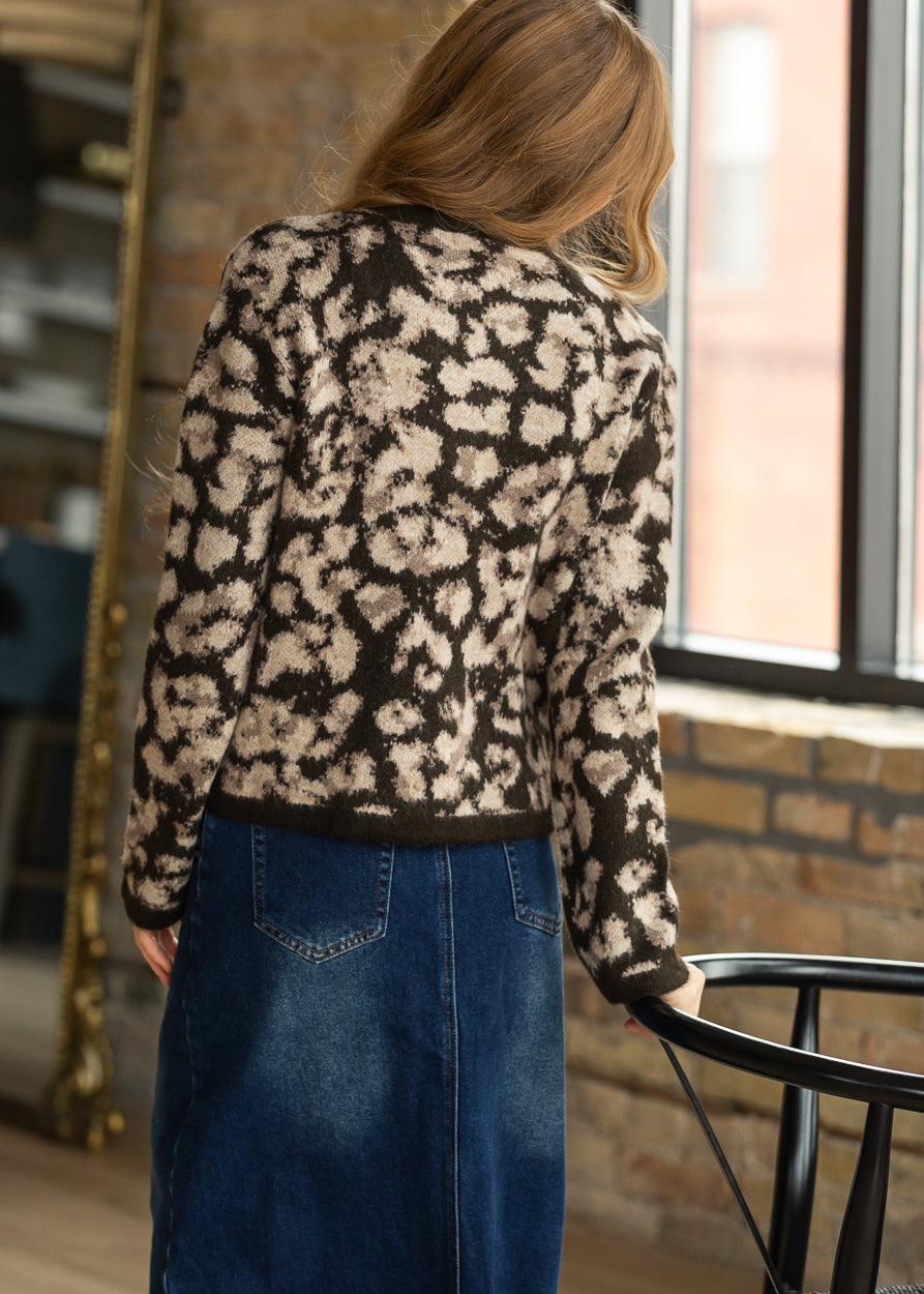 Brown animal print sweater styled with a denim maxi skirt and brown clogs.