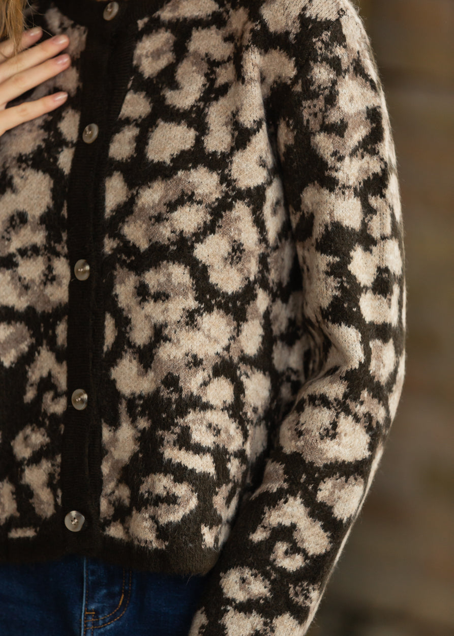 Close-up of brown and taupe animal print knit sweater with contrast button placket.