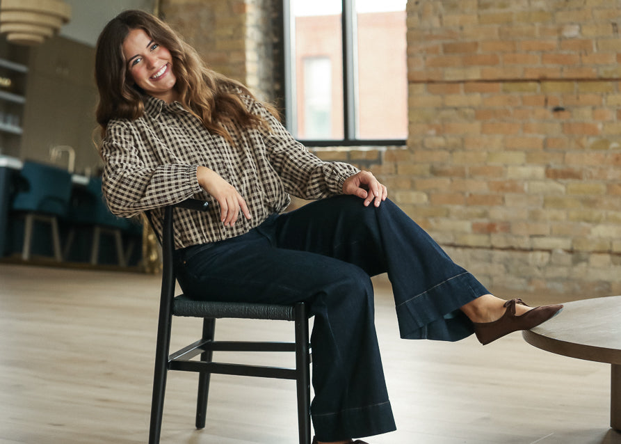 Detailed view of coffee gingham bomber jacket with button-front neckline.
