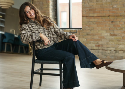 Detailed view of coffee gingham bomber jacket with button-front neckline.