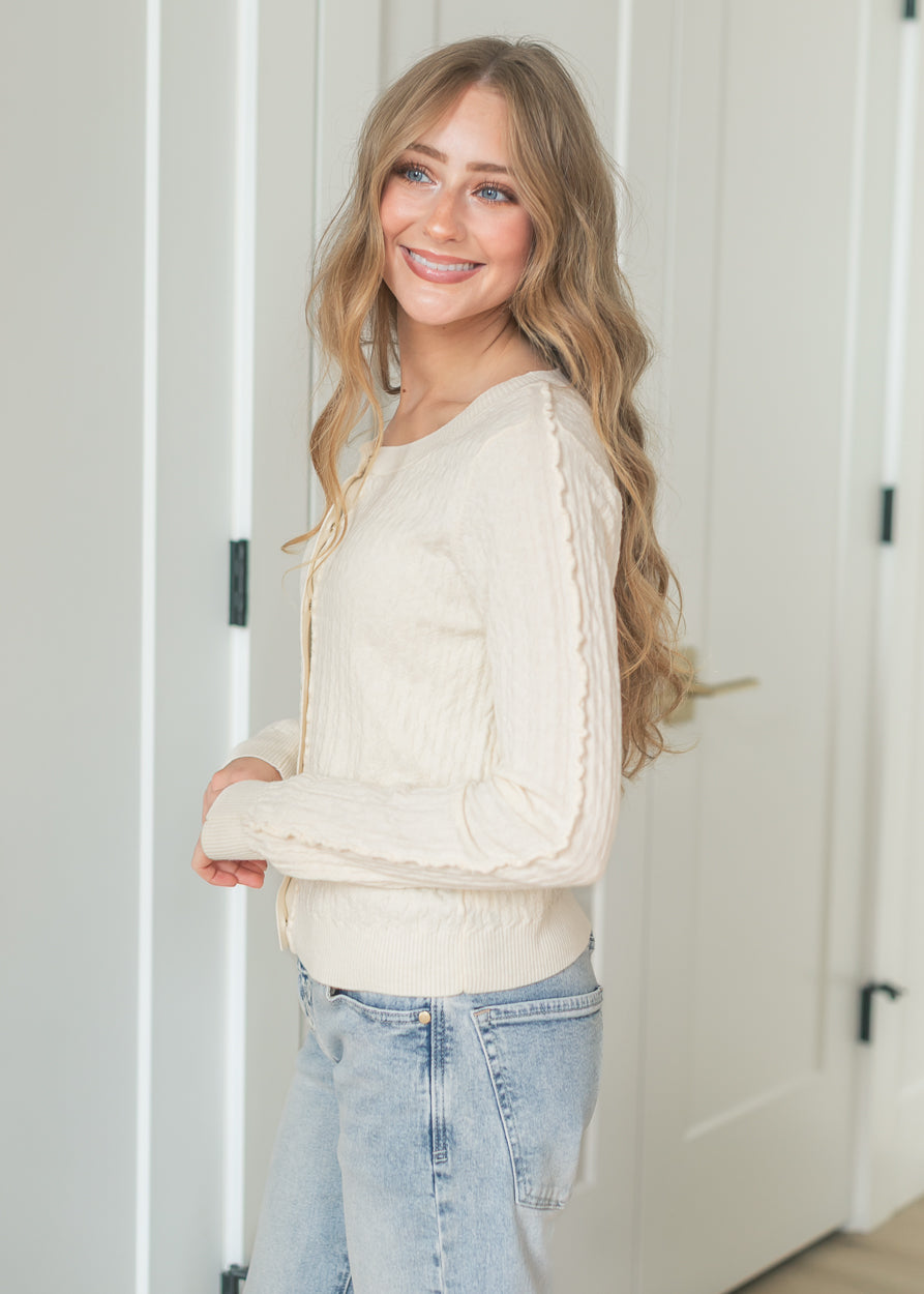 Front view of cream knit cardigan with gold-tone functional buttons