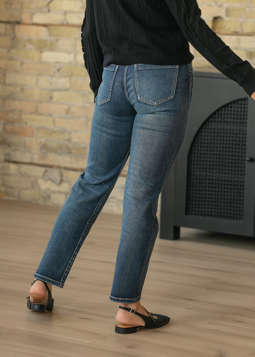 Back of dark wash slim jeans showing classic patch pockets and fitted seat.