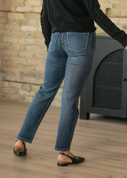 Back of dark wash slim jeans showing classic patch pockets and fitted seat.