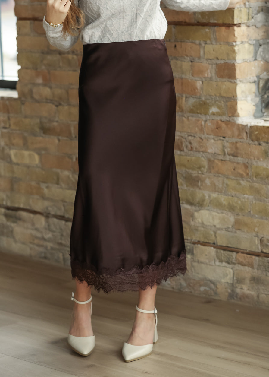 Chocolate brown satin midi skirt styled with a cream sweater and ankle-strap heels