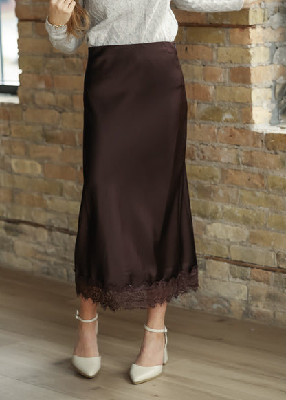 Chocolate brown satin midi skirt styled with a cream sweater and ankle-strap heels