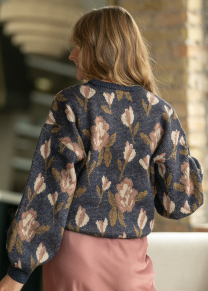 Back of navy floral long sleeve sweater showing loose fit, hip-length hem, and allover floral pattern.