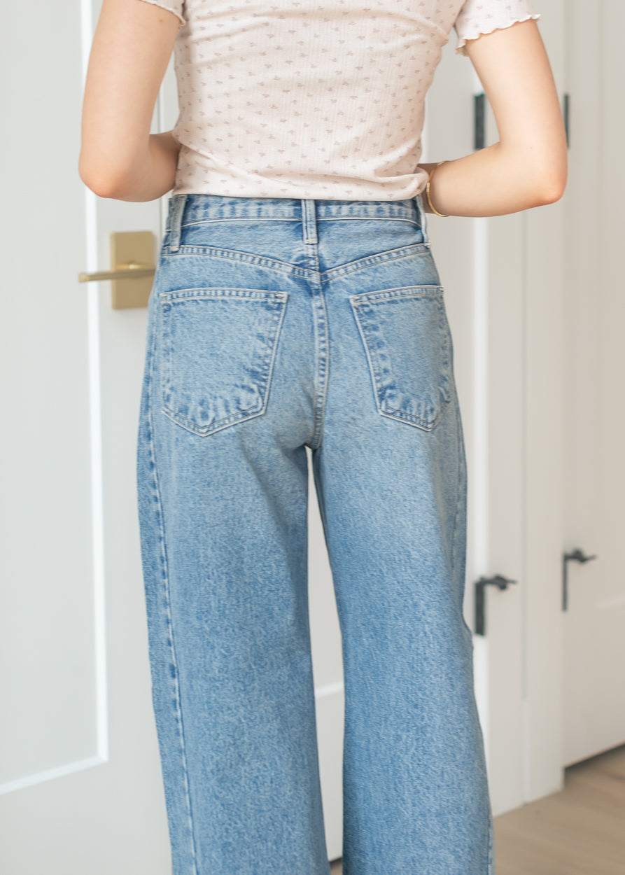 Casual outfit featuring medium wash barrel jeans and neutral sandals
