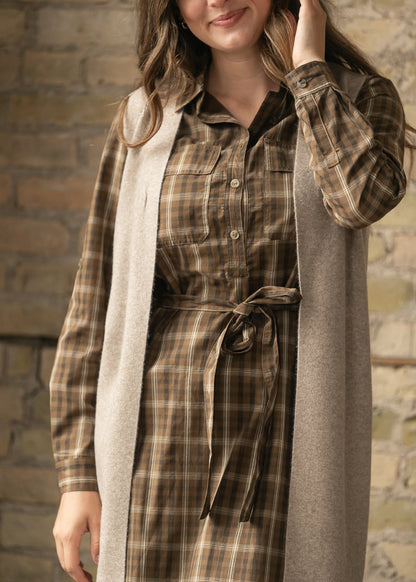 Close-up of the brown plaid cotton dress showing the functional button front and self-tie waist.