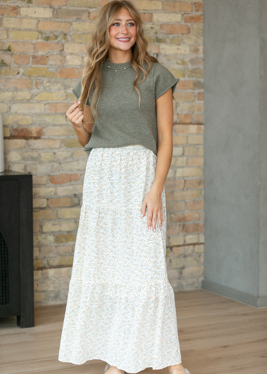 Full-length styling of light olive sweater T-shirt with a cream floral maxi skirt.