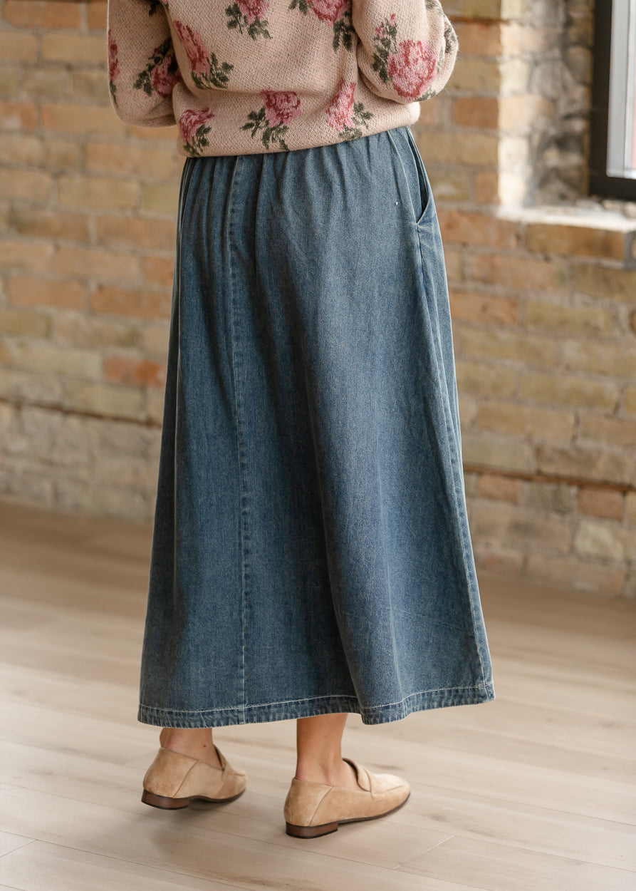 Back of medium wash denim midi skirt with A-line silhouette and softly gathered waist.