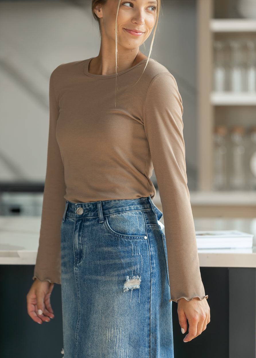 Side profile of the brown ribbed top, showing the fitted long sleeve and lettuce cuff detail.