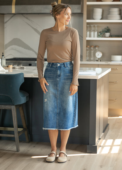 Long sleeve brown ribbed top tucked into a denim skirt, styled for an easy everyday look.