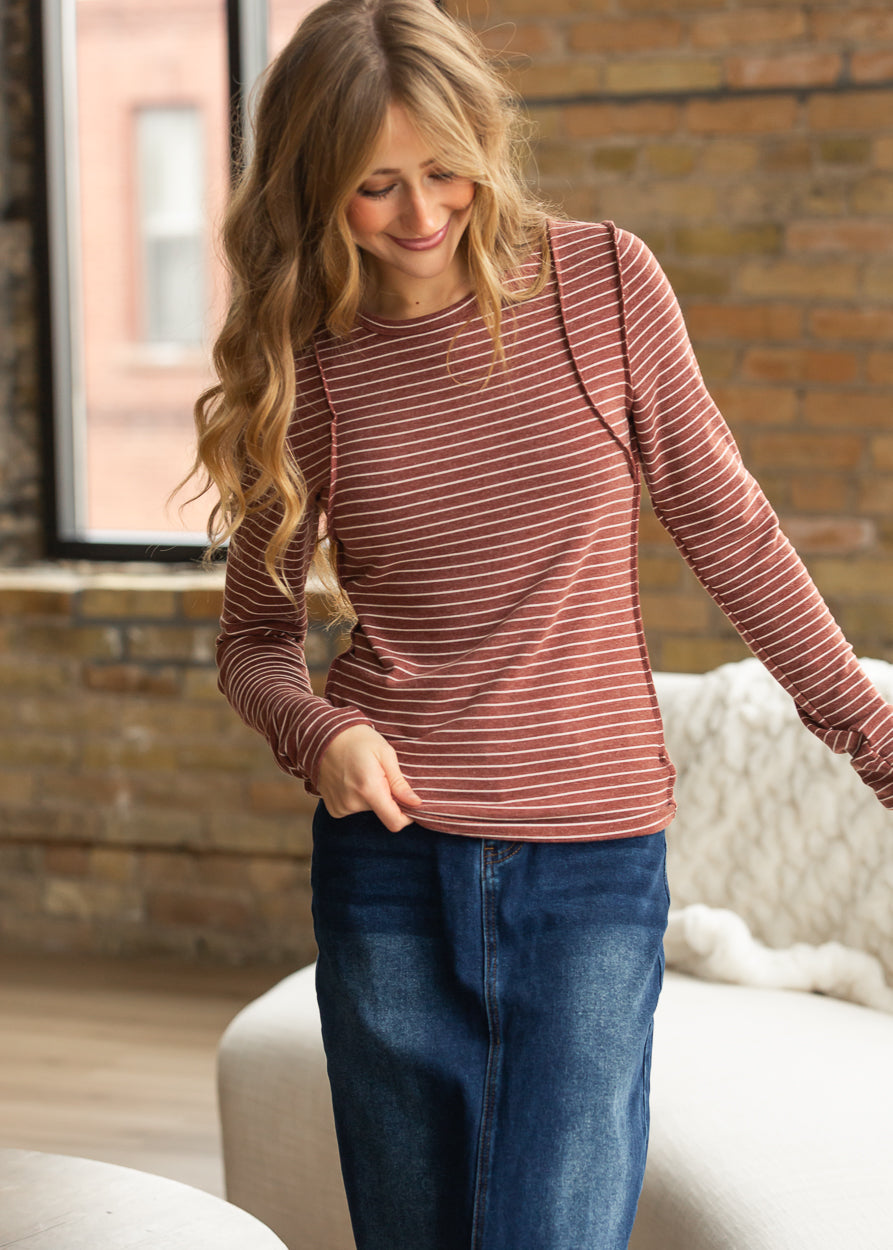 Maroon striped long sleeve top styled casually with a denim maxi skirt and sneakers.