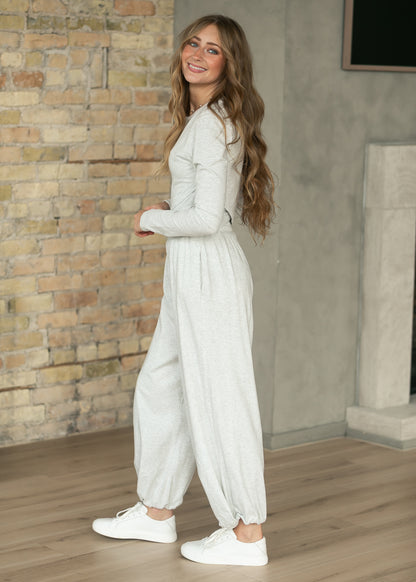 Side view of heather gray fitted long sleeve top with matching loose jogger pants.