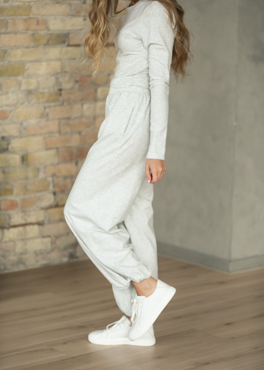 Heather gray jogger pants with elastic ankle cuffs, styled with white sneakers.