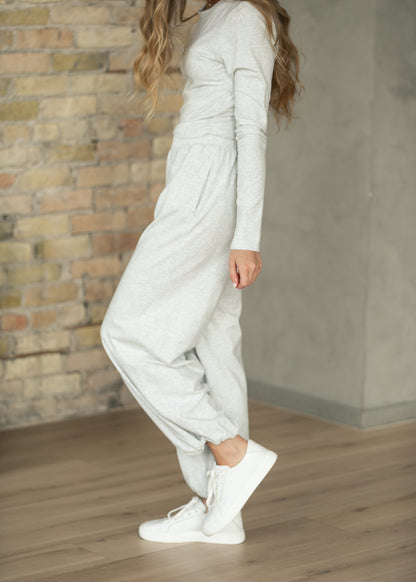 Heather gray jogger pants with elastic ankle cuffs, styled with white sneakers.
