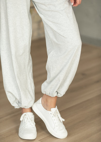 Heather gray loose fit jogger pants from the back with elastic ankle cuffs.
