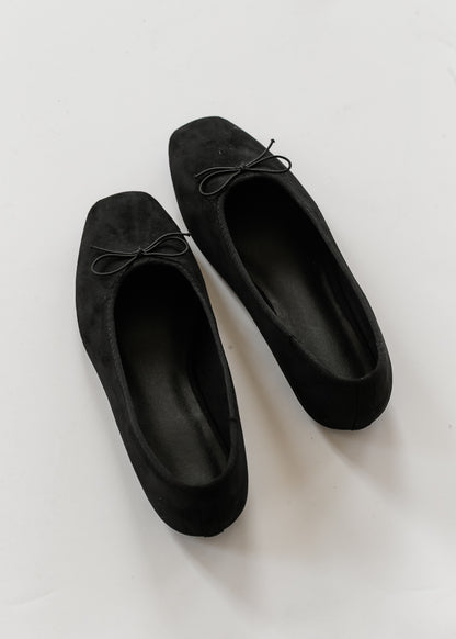 Overhead view of black bow ballet flats showing softly squared toes and simple slip-on shape.