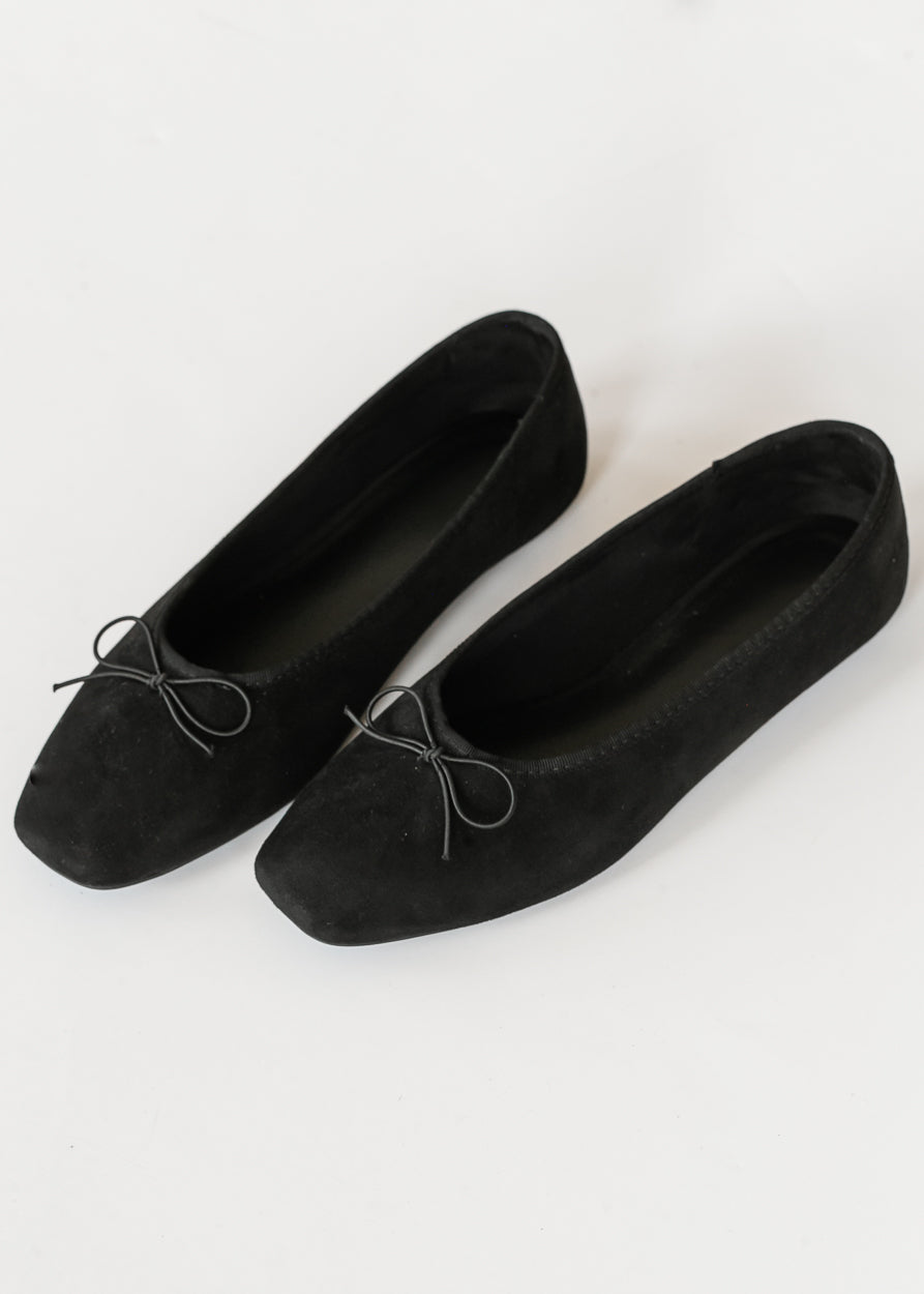 Black bow ballet flats with softly squared toes and velvety finish on a white background.