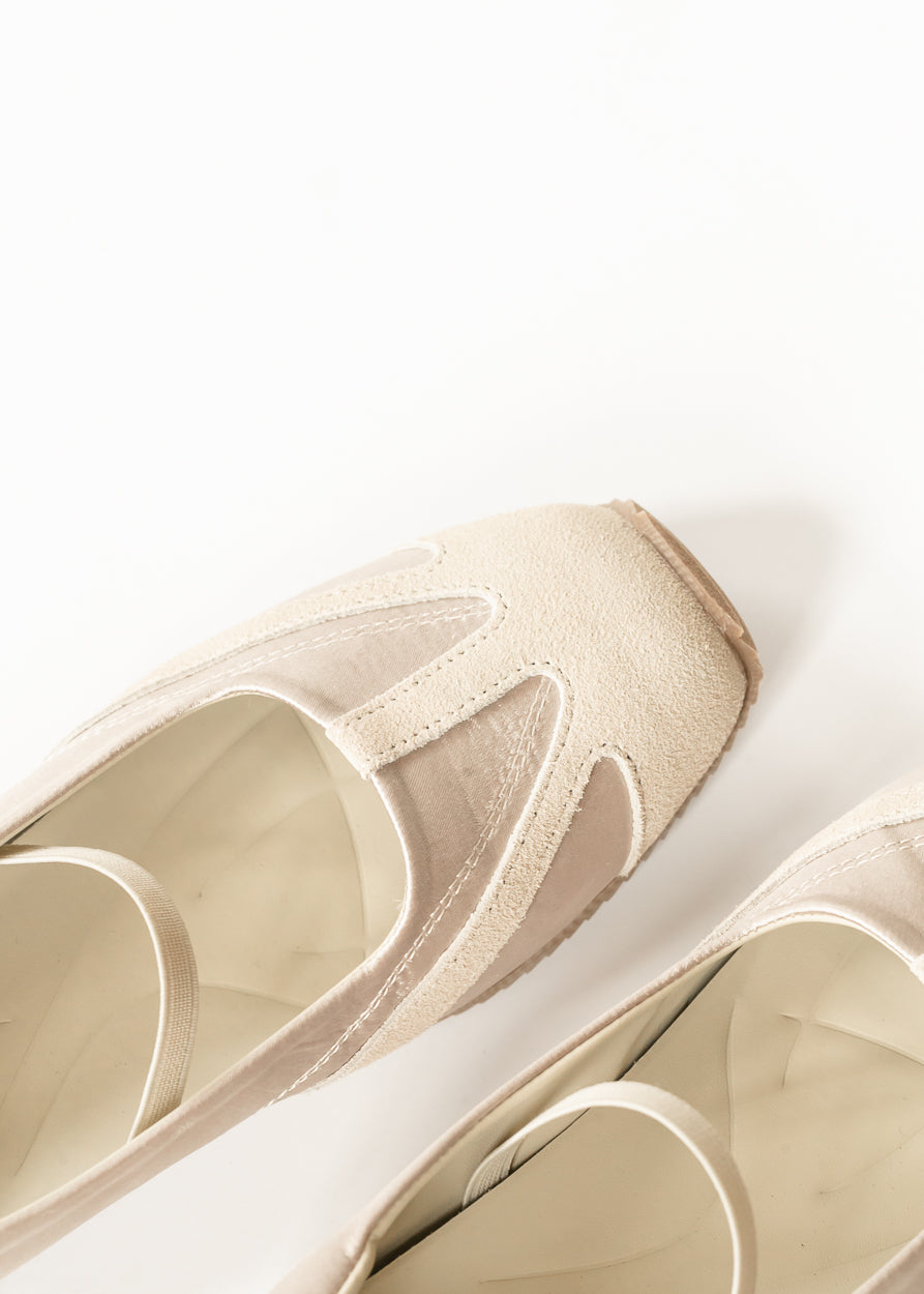 Close-up of ivory shimmer flat showing tonal toe paneling, mixed textures, stitching, and elastic instep strap.