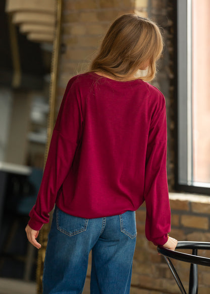 Back of maroon cotton modal long sleeve top showing the loose fit and drop shoulder design.
