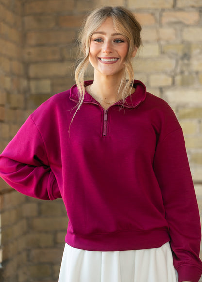 Maroon quarter-zip mock neck sweatshirt with ribbed cuffs, zipped high for a cozy layered look.