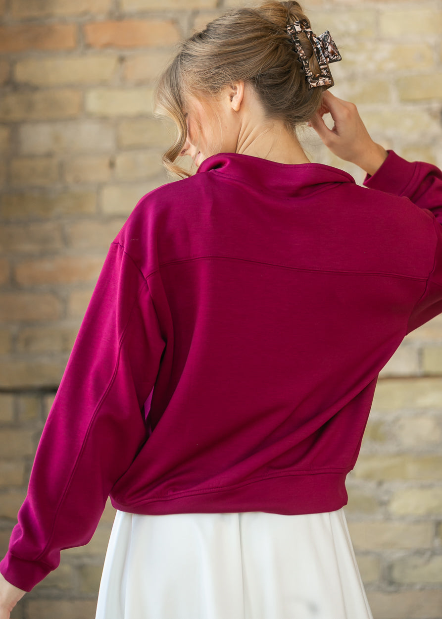 Back of maroon quarter-zip sweatshirt showing the yoke seam and funnel mock neck.