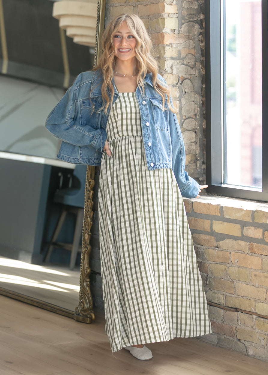 Gingham maxi dress styled with a denim jacket and woven flats.