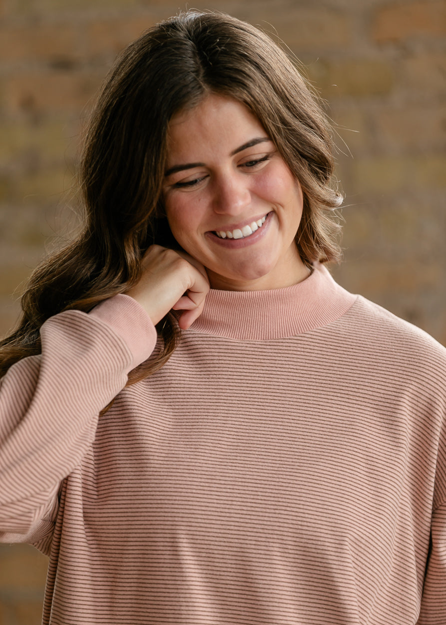 Close-up of mauve olive striped mock neck top showing the ribbed neckline and fine stripe texture.