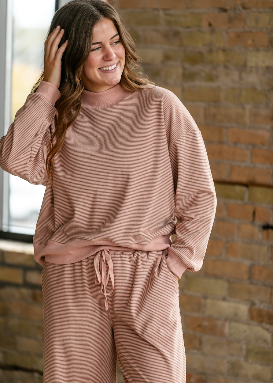 Mauve olive striped mock neck top with ribbed trim styled as part of a matching lounge set.
