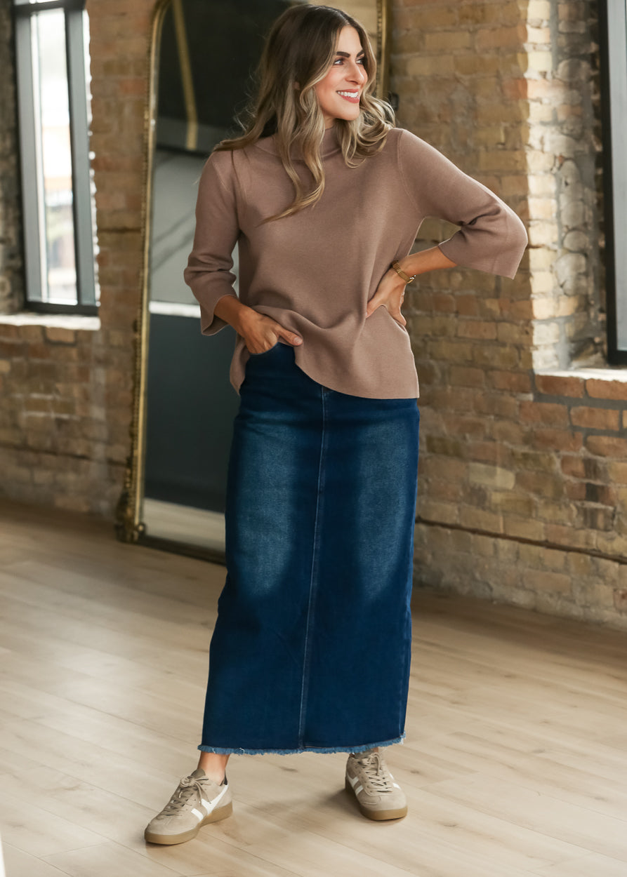 Dusty brown bell sleeve sweater styled with a dark wash denim maxi skirt and neutral sneakers.
