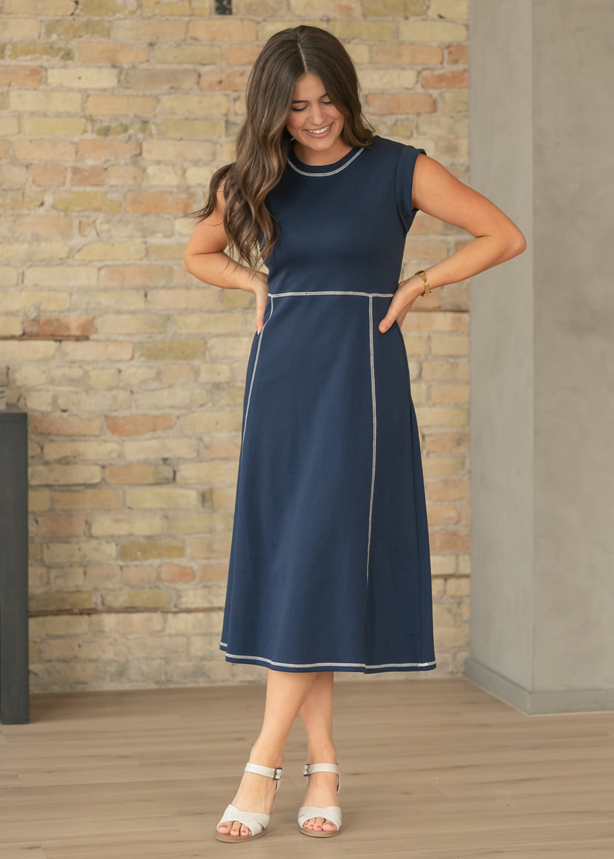 Front view of navy contrast stitch midi dress with fitted bodice and flowy midi skirt.