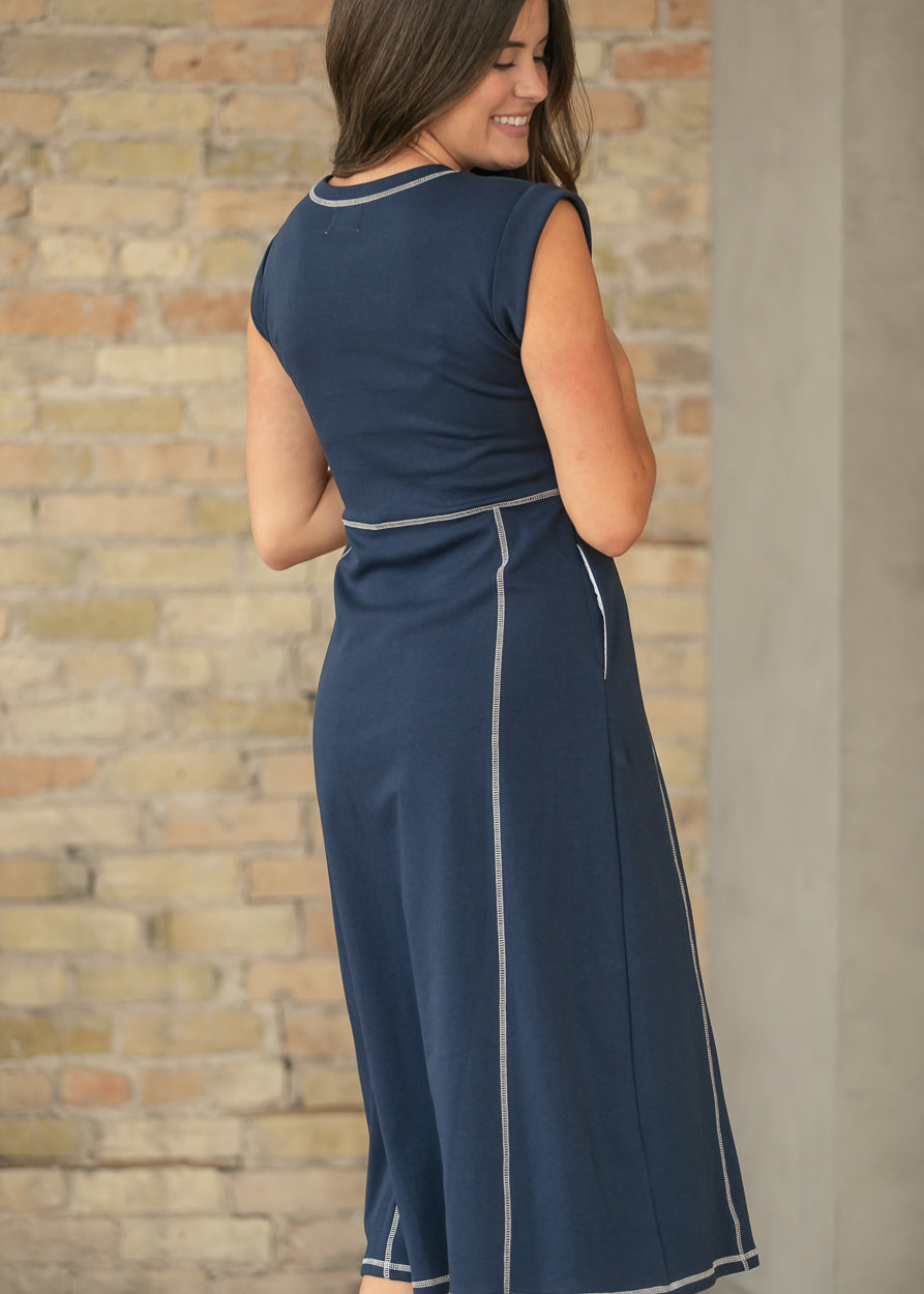Close-up back view of navy midi dress with cream stitching and soft stretch fabric.