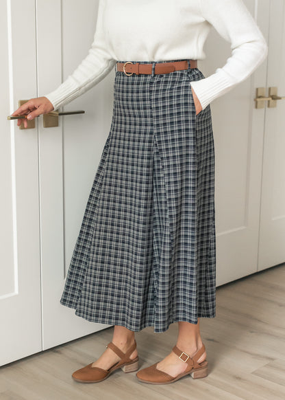 Navy plaid flare maxi skirt styled with an ivory sweater, brown belt, and coordinating heels.