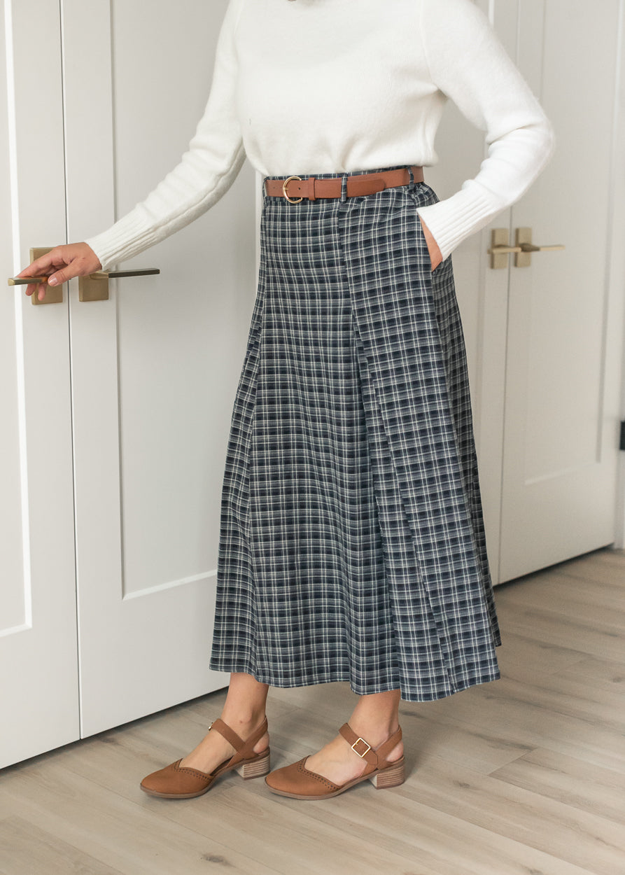Navy plaid belted maxi skirt with side pockets and a flowing flared silhouette.