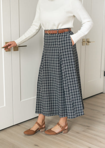 Navy plaid belted maxi skirt with side pockets and a flowing flared silhouette.