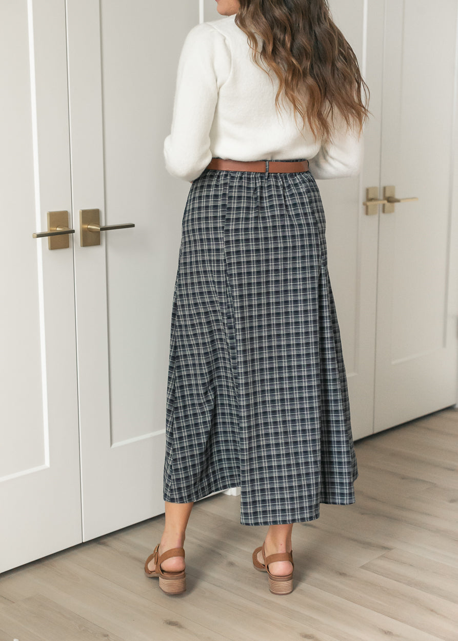 Back of navy plaid flare maxi skirt showing the full silhouette and belted high waist.
