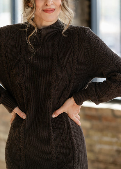 Close-up of chocolate brown sweater dress showing cable knit texture, diamond stitching, and ribbed mock neckline.