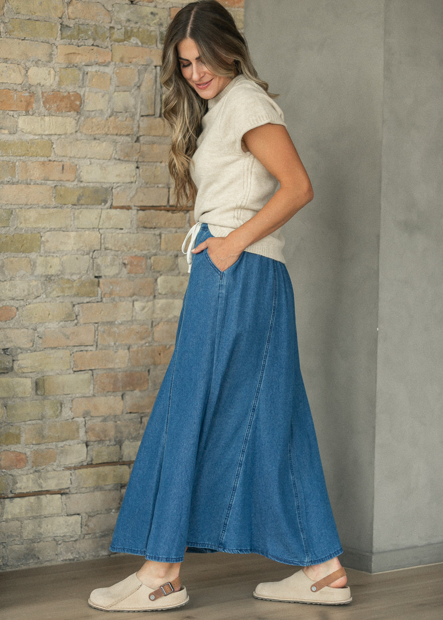 Stone crewneck sweater T-shirt with short rolled sleeves, styled with a blue denim maxi skirt.