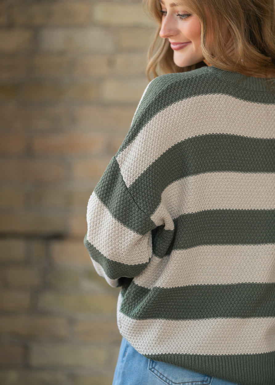 Close-up back view of olive striped sweater showing textured knit and ribbed hem.