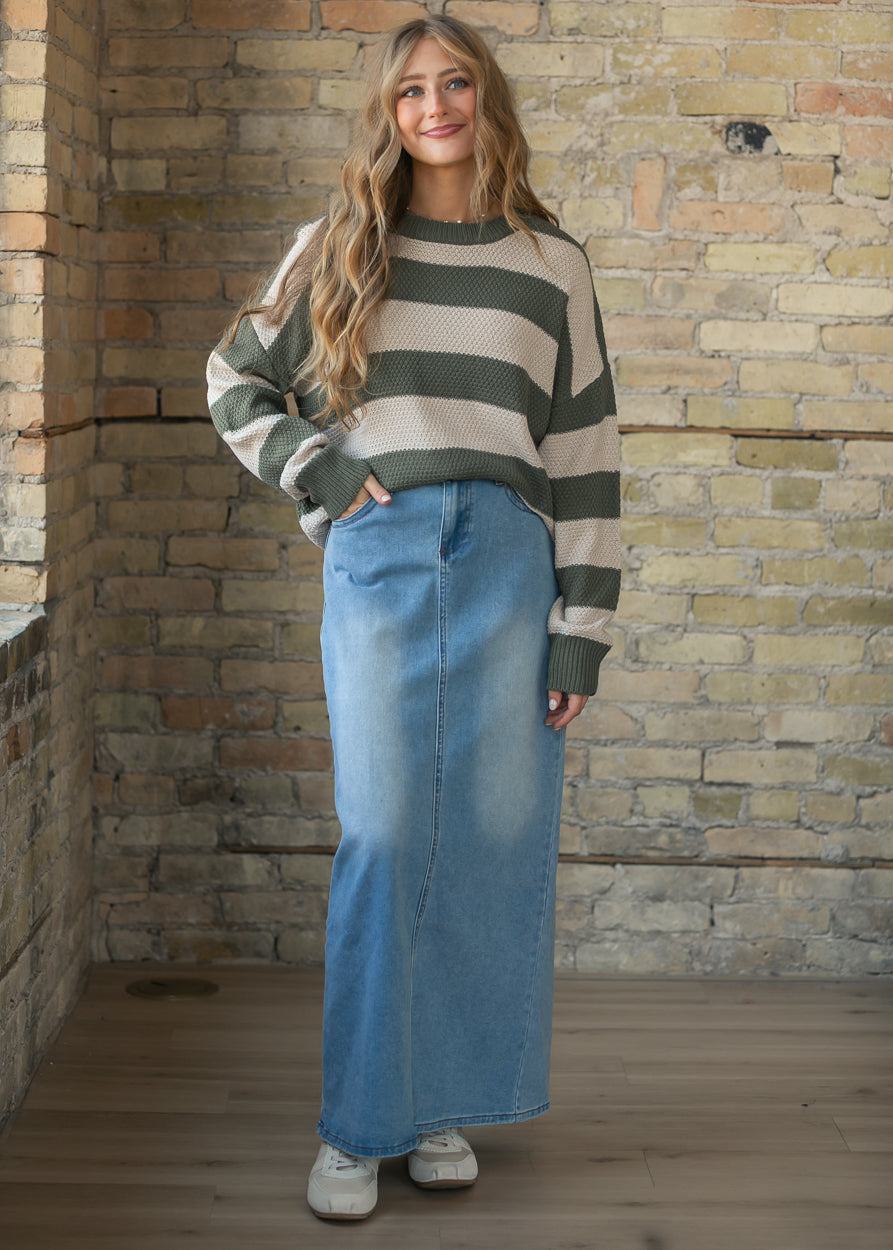 Olive striped crewneck sweater styled with a light wash denim maxi skirt and sneakers.