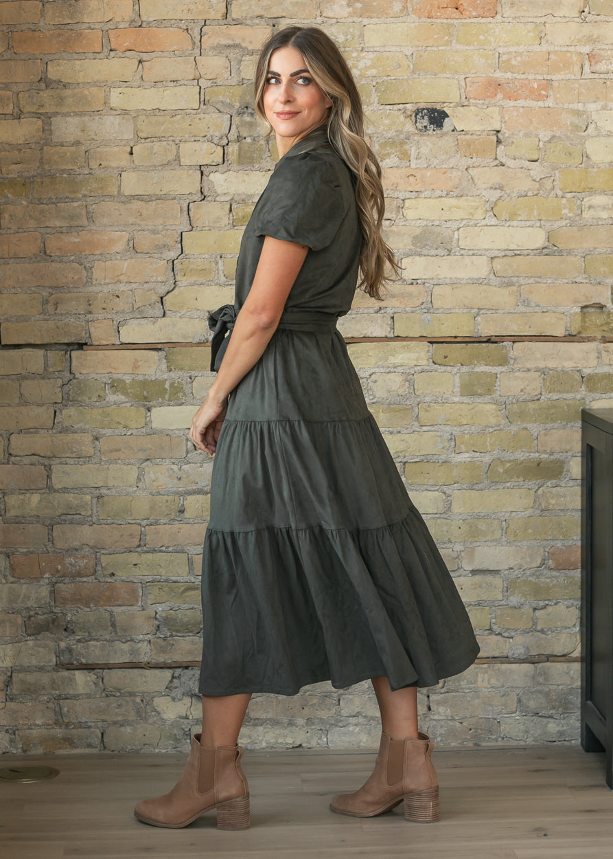 Olive suede midi dress with short sleeves, tie waist, and tiered skirt, shown from the side.