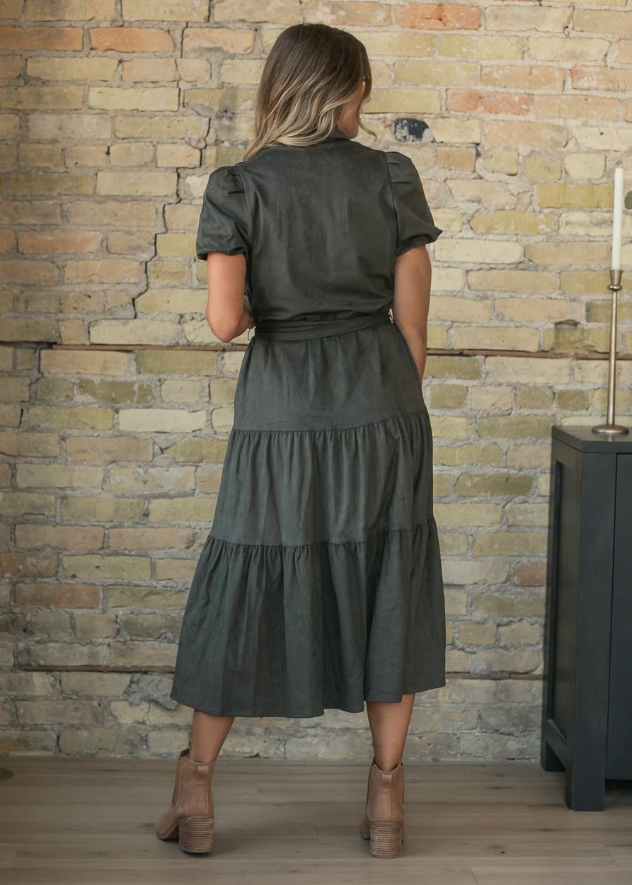 Olive suede tiered midi dress with tie waist and short sleeves, styled with brown ankle boots.