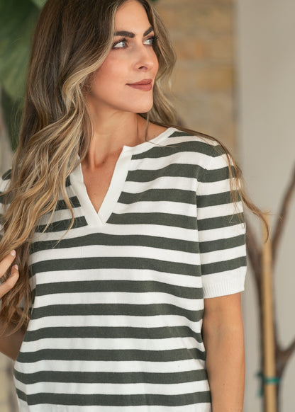 Close-up of the notch v-neckline on an olive and ivory striped sweater top.
