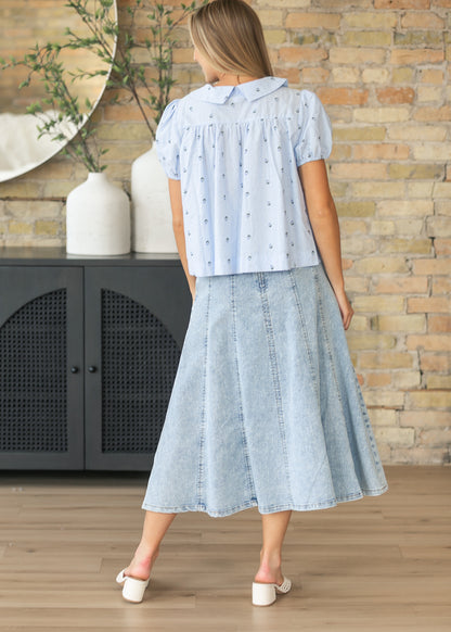 Back view of the light wash paneled denim midi skirt with flowing silhouette.
