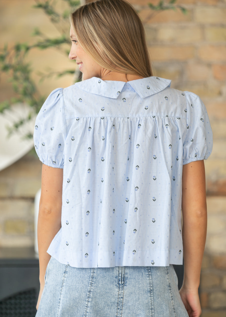 Back of the light blue floral jacquard blouse showing the gathered yoke and Peter Pan collar.