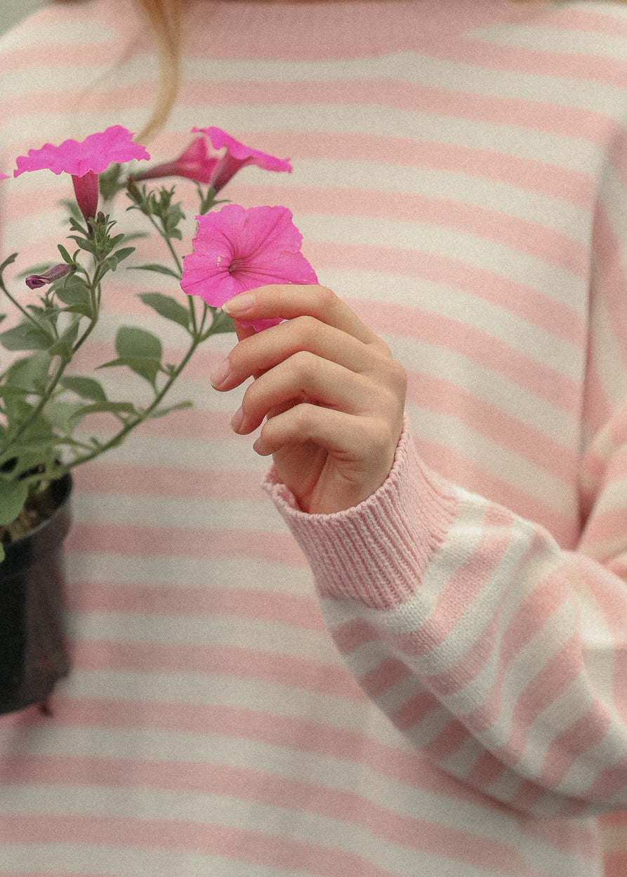 Pink and cream striped knit sweater styled with a light wash denim midi skirt in natural daylight.