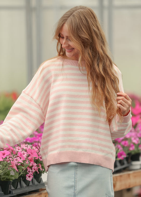 Pink and cream striped knit sweater styled with a light wash denim midi skirt in natural daylight.
