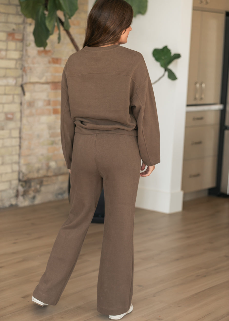 Brown wide leg joggers with straight flowing legs and relaxed fit, shown from the back with matching brown sweater.