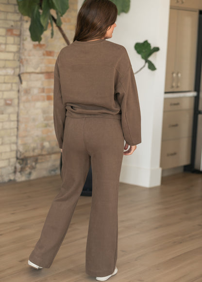 Brown wide leg joggers with straight flowing legs and relaxed fit, shown from the back with matching brown sweater.